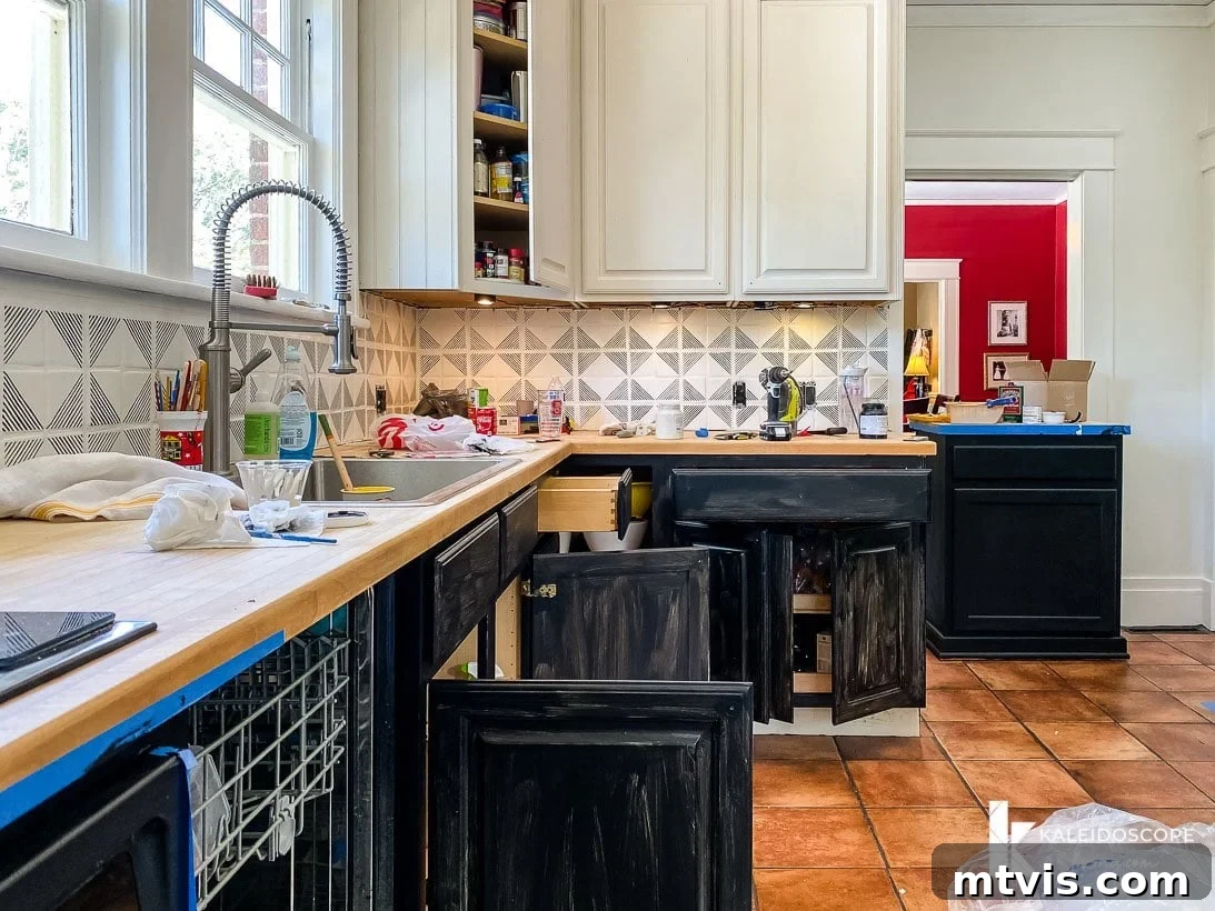 Is Painting Your Kitchen Cabinets Right for You? Essential Questions Before You Begin 8 View of a kitchen mid-transformation, with cabinet doors removed and prepped for painting.