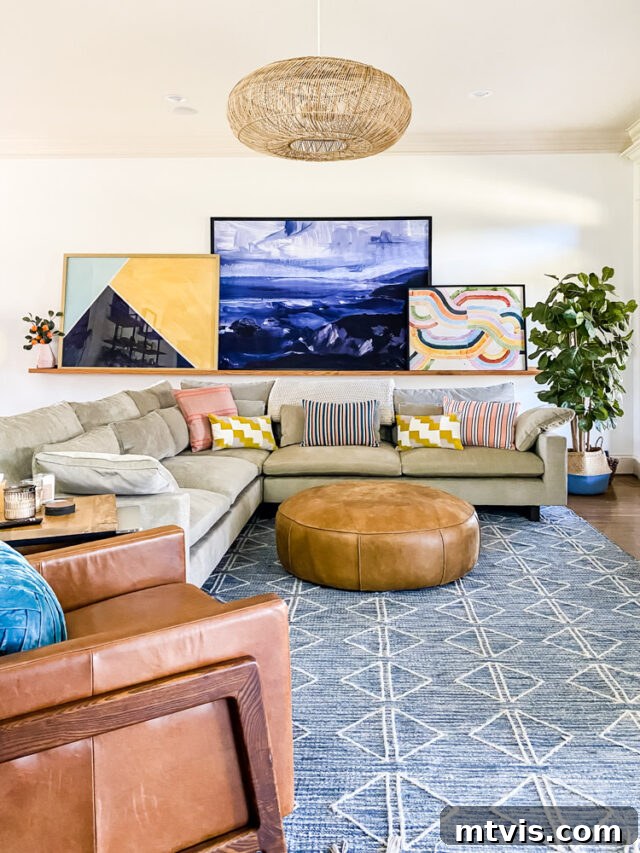 Transform Your Space: 27 Gallery Wall Ideas and Practical Hacks 13 A contemporary family room featuring an oversized art gallery displayed on a custom DIY art ledge, showcasing large pieces leaned against the wall for a modern, flexible aesthetic.