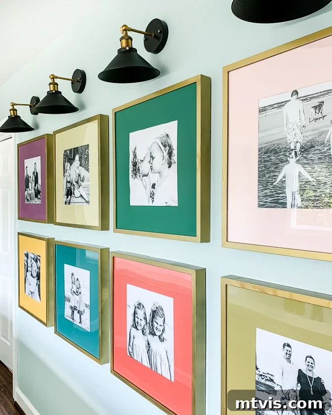 Transform Your Space: 27 Gallery Wall Ideas and Practical Hacks 10 A long hallway featuring a symmetrical gallery wall of family photos, each enhanced with vibrant, colorful photo mats, creating a lively and personalized display.