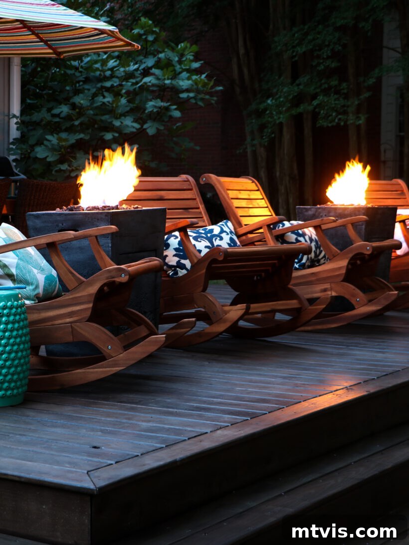 Two modern fire columns flanking comfortable outdoor rocking chairs on a newly renovated deck, creating a warm and inviting ambiance for evening relaxation.
