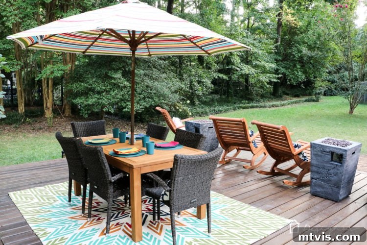 A wide shot of the expansive DIY deck, highlighting the wrap-around stairs, the new dark stain, and the various seating zones for relaxation and entertainment.