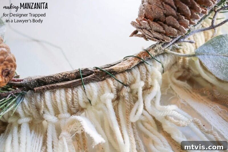 Craft Your Boho Winter Wreath 7 Attach two frosted holiday floral picks to the bottom of your DIY Boho Winter Wreath using floral wire. Overlap the picks and leave a central gap for the upcoming mini sisal trees, enhancing the winter aesthetic.