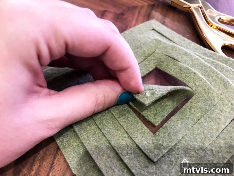 Craft Charming Felt Ornaments for Christmas 6 First step of assembling a felt ornament, showing a corner folded and secured with hot glue.