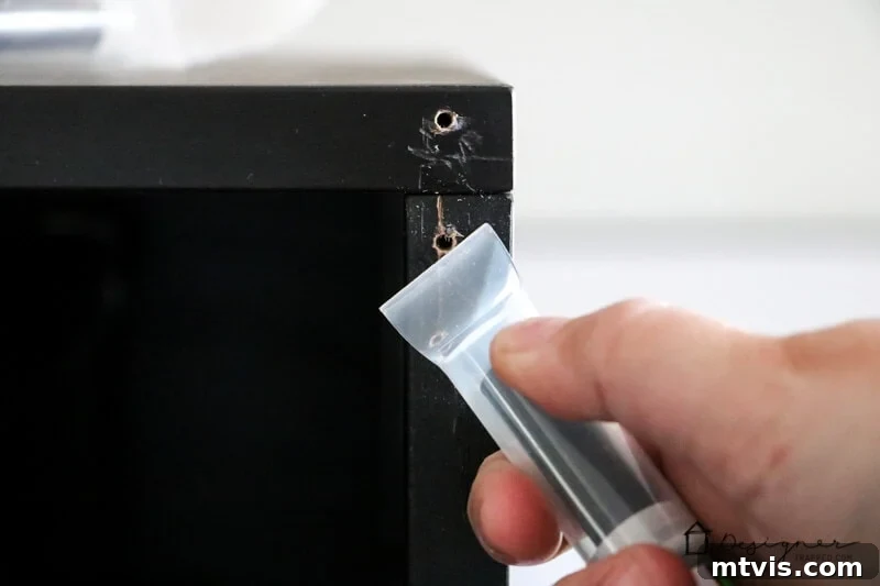 Seamlessly Repair Furniture to Match IKEA Hues 4 A close-up of a hand using a Leveler Cap to clean-up furniture damage. IKEA furniture repair can be easy and budget friendly.