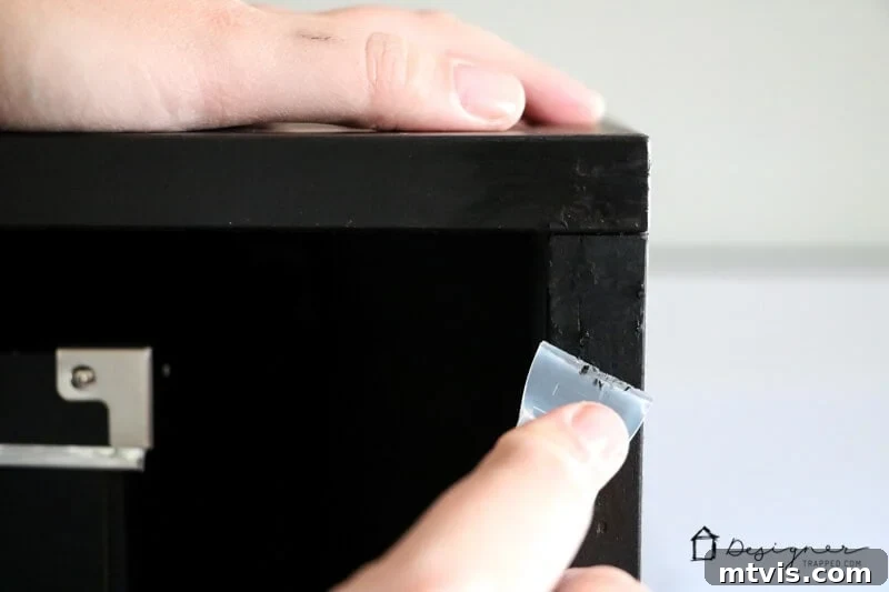 Seamlessly Repair Furniture to Match IKEA Hues 8 A woman's finger scrapes any excess residue from repaired furniture using a Leveler Cap.