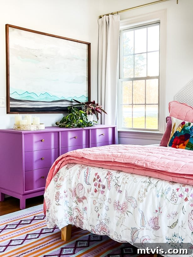 Space-Saving Secrets: 9 Genius Hacks for Bigger-Looking Rooms 9 A purple dresser next to a pink bed and bright window. The furniture has legs to make a small room look bigger. The visible floor beneath adds to the room's airy and expansive feel.