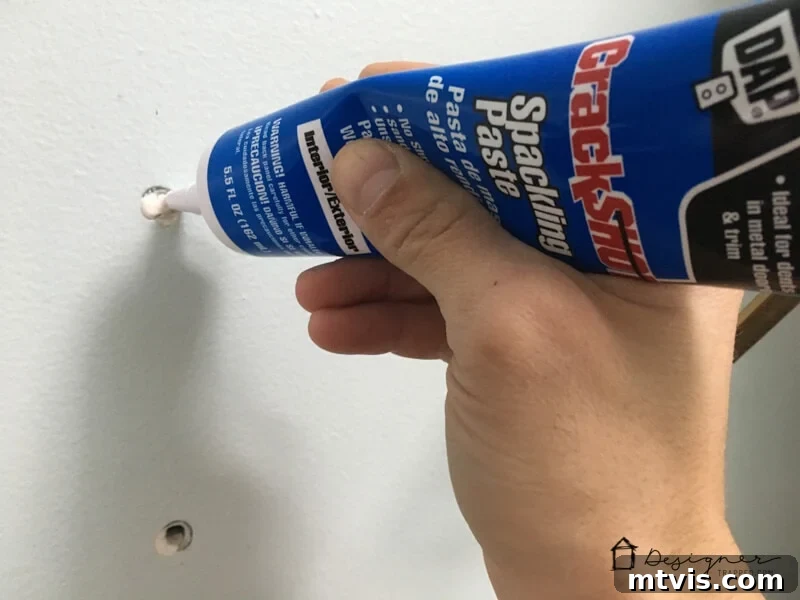 How to Repair Drywall: Tips for Minor Repairs 3 filling hole in wall with spackling paste