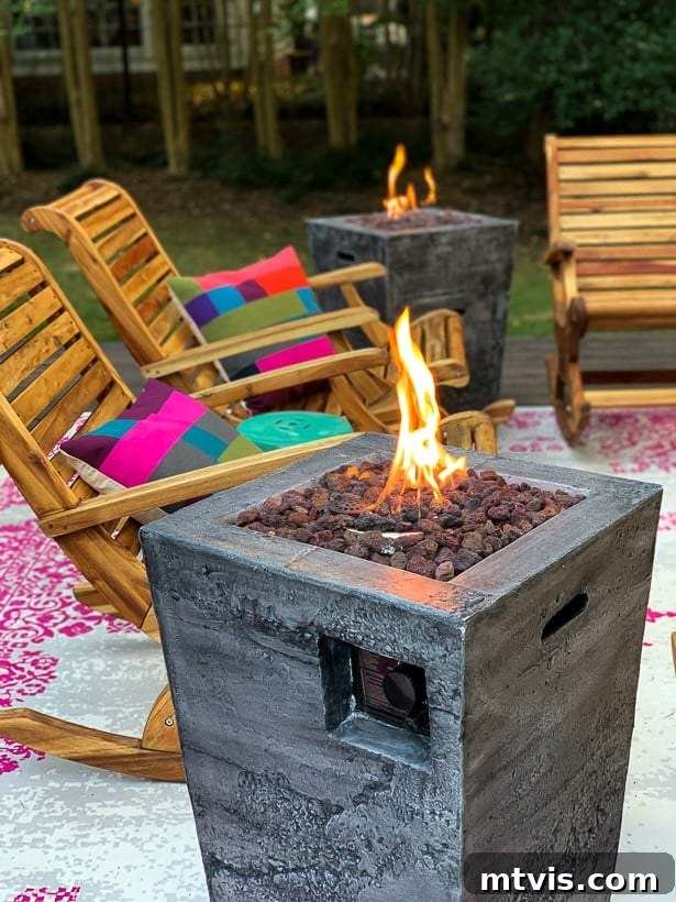 From Cozy Corners to Grand Gatherings: Fire Pit Ideas for All Spaces 3 Fire columns on a vibrant backyard deck beside comfortable rockers and colorful checkered pillows, creating a lively outdoor seating area.