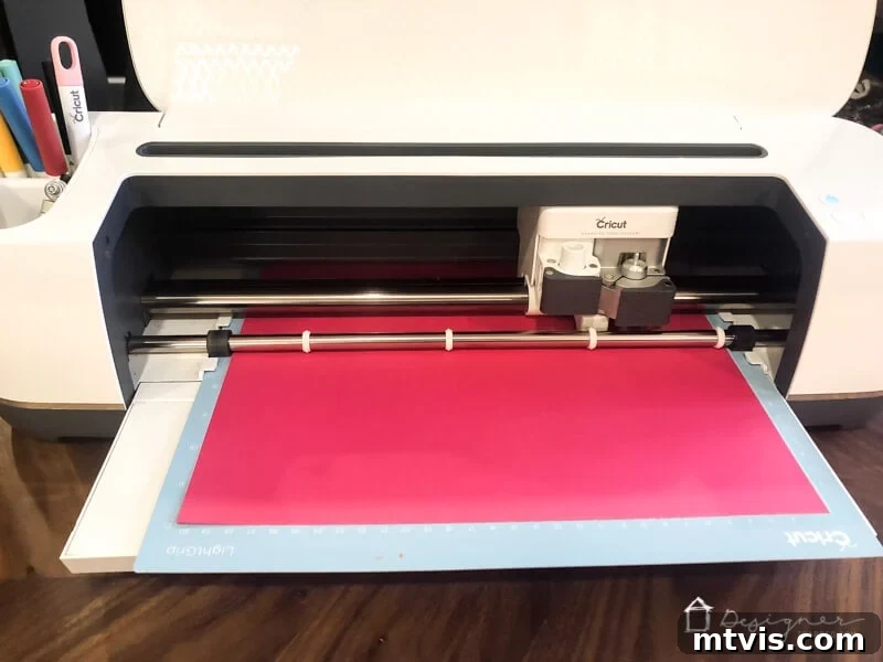 Craft Custom Photo Mats for Pennies 4 Cricut machine cutting a precise opening for a DIY picture mat from pink cardstock.