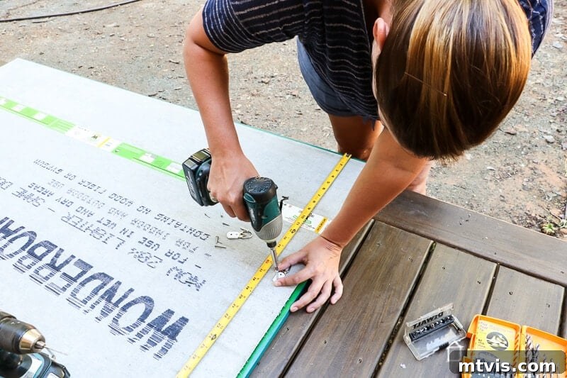 Attaching mirror hanging hardware to the back of the outdoor chalkboard frame.