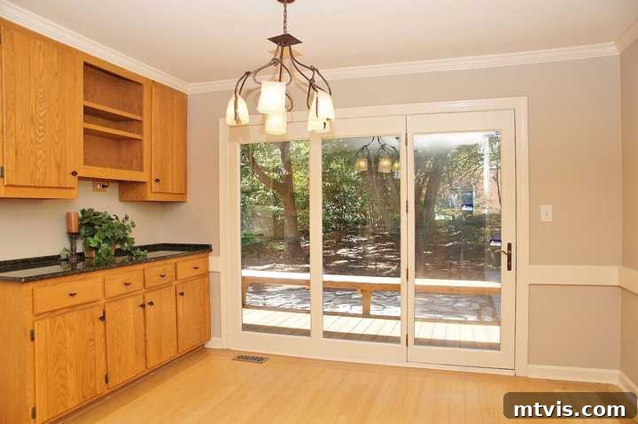 Before image of the kitchen's eat-in area, highlighting cramped cabinets and an outdated chandelier.