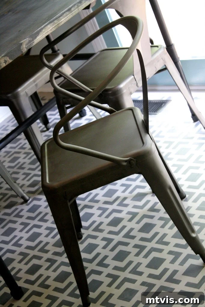 Industrial metal chairs and herringbone plank wall detail in the budget kitchen remodel.
