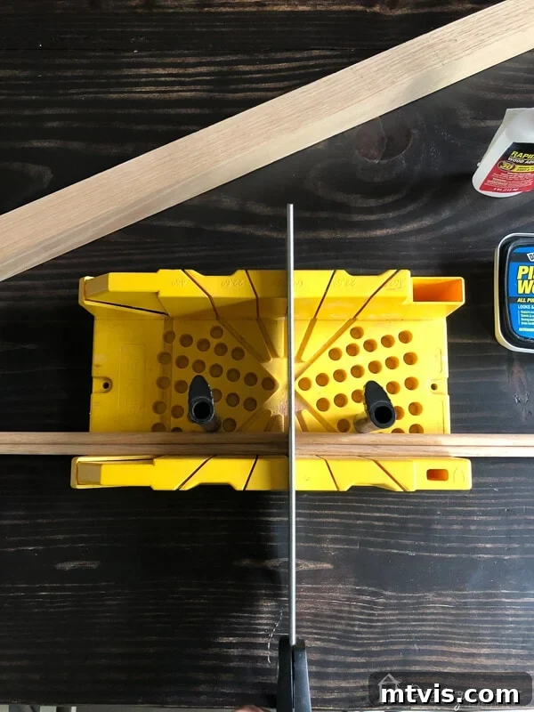 Sparkle and Store: DIY Jewelry Organizers for Every Piece 9 Hand saw cutting a wood dowel in half