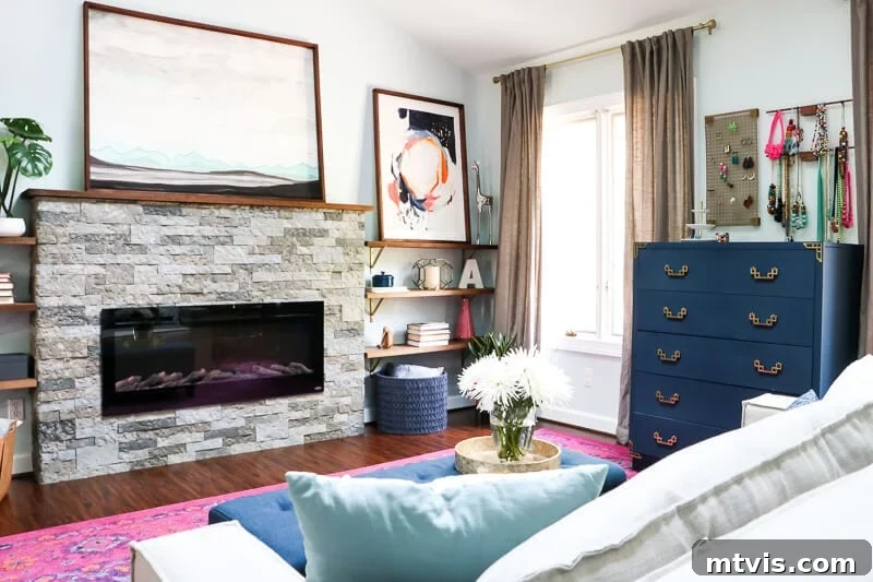 Our Blush and Indigo Sanctuary Unveiling 6 Elegant pink and navy master bedroom showing the comfortable sitting area with sofa, bench, and fireplace