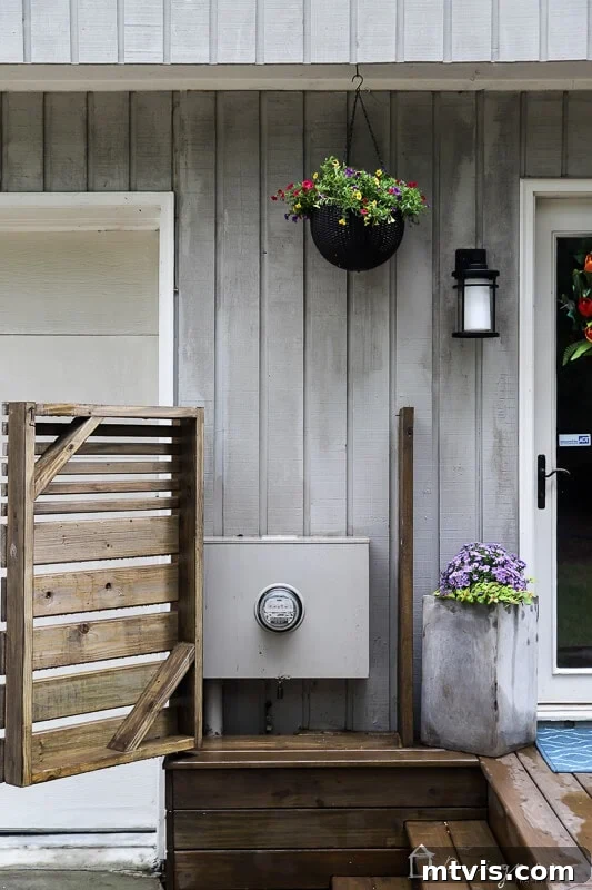 Image showcasing the DIY wooden electrical box cover with its hinged door fully open, revealing the hidden utility boxes behind it.