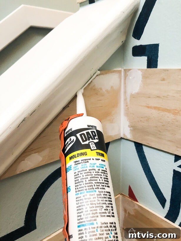 Applying caulk with a caulk gun to seal seams on the plank wall, ensuring a neat finish.