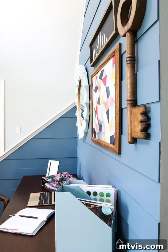 A chic, modern desk setup integrated into the plank wall design of the foyer.