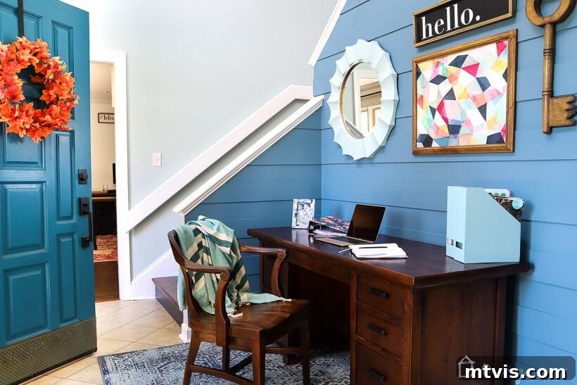 Wide shot of the transformed foyer, highlighting the modern plank wall and inviting ambiance.