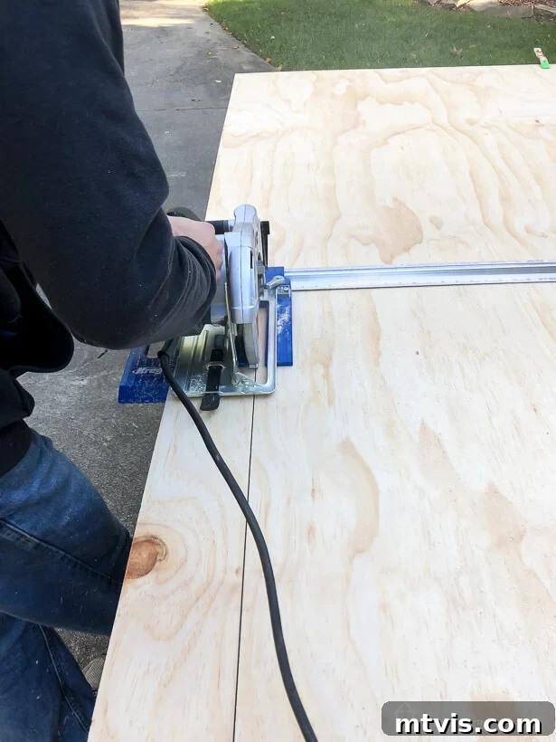 Using a circular saw with a guide to accurately rip plywood into uniform planks.