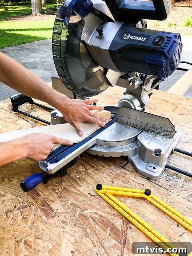 Cutting a wooden plank to an angle using a compound miter saw.