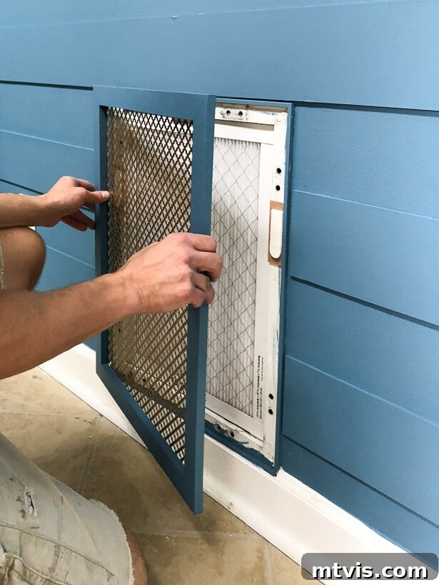 Stylish DIY Vent Cover Made Simple 11 Final installation of a decorative DIY air vent cover on a plank wall.
