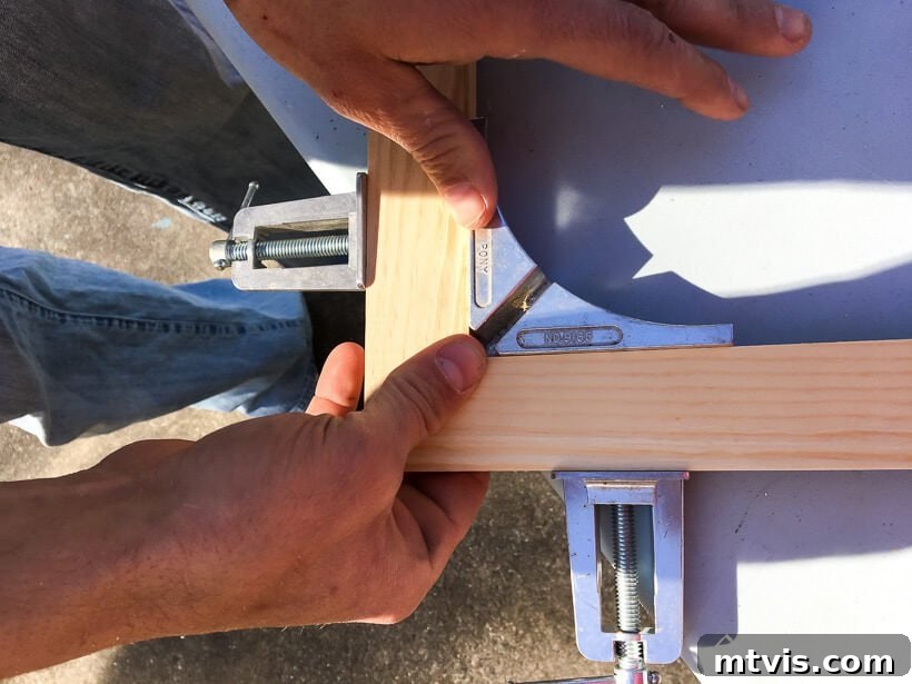 Stylish DIY Vent Cover Made Simple 4 Corner clamp holding mitered wood pieces together for a precise joint.