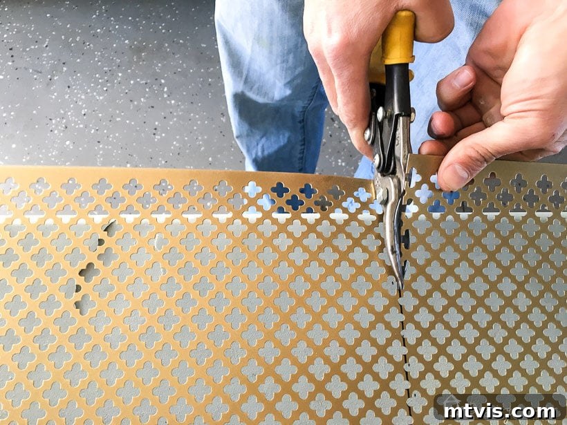 Stylish DIY Vent Cover Made Simple 6 Metal snips being used to trim a decorative metal screen for a DIY project.