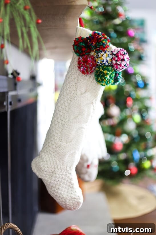 Christmas stocking with pompom details on a festive mantel