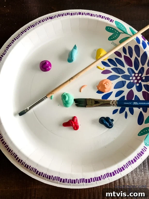 Craft Your Own Hand-Painted Christmas Ornaments 3 Acrylic paints squeezed onto a paper plate, ready for painting Christmas ornaments.