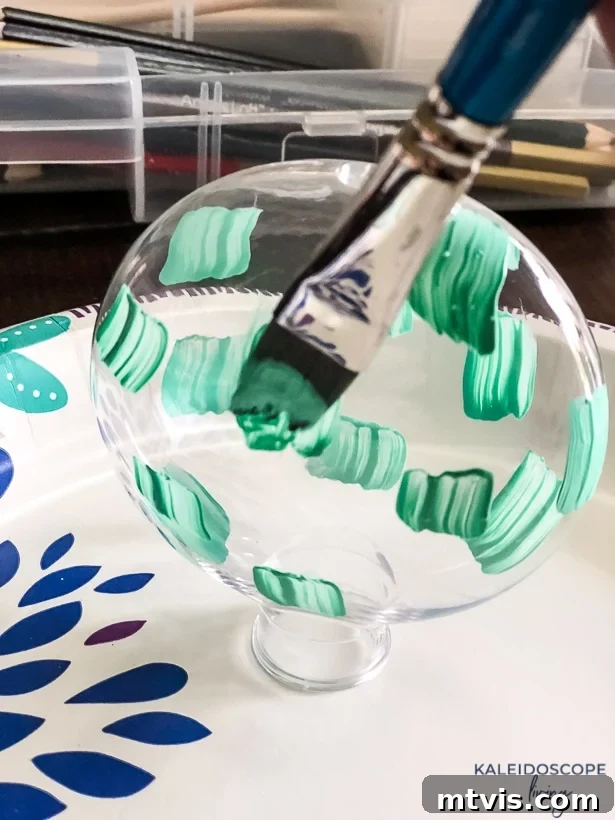 Craft Your Own Hand-Painted Christmas Ornaments 4 Close-up of an ornament with the first layer of colorful brush marks drying.