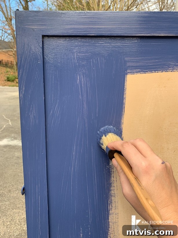 Chalk Paint Secrets: Your Complete Guide to Furniture Makeovers 7 Behr Chalk Decorative Paint in Timeless Blue being applied to a piece of furniture, showing the ease of use and beautiful coverage achieved with chalk paint. Focus on even coats.