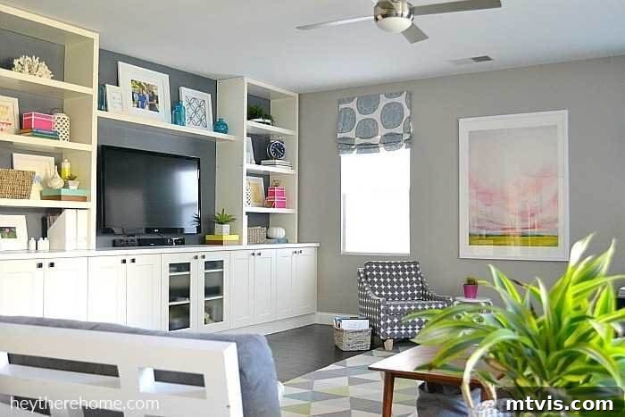 IKEA Smart Hacks: Custom Built-Ins and Bookshelf Upgrades 10 A living room with built-ins made from IKEA kitchen cabinets and shelves along the entire wall hold a TV, books, and kick-knacks.