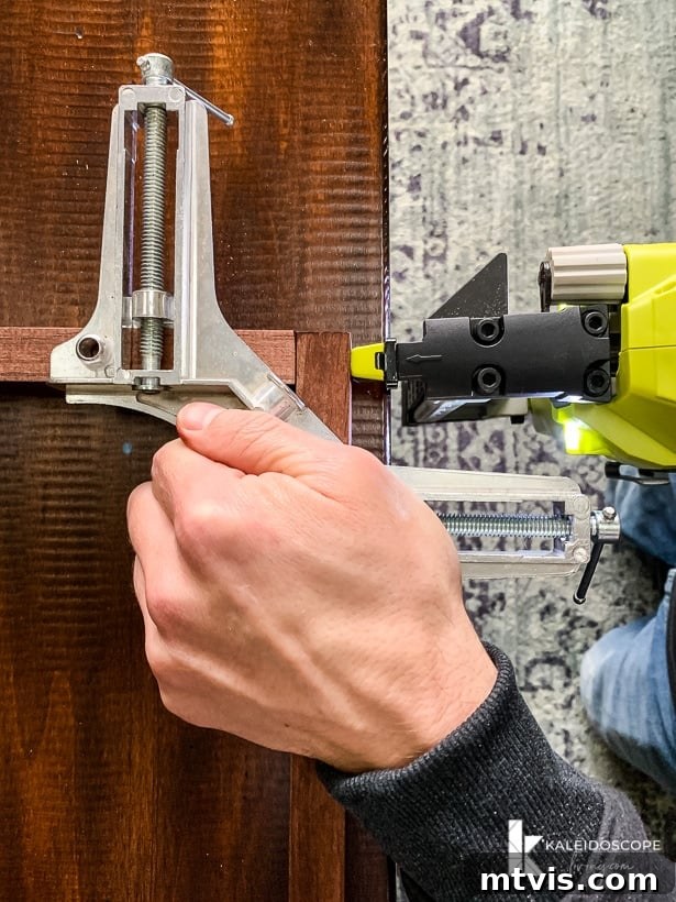 DIY Oversized Frames Stunning Decor Under $20 7 Assembling wooden frame with clamps and nailer.