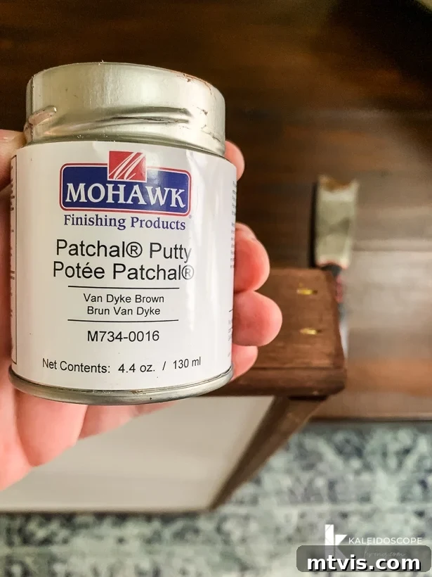DIY Oversized Frames Stunning Decor Under $20 10 Applying Patchal Putty to hide nail holes in DIY frame.