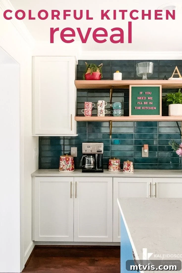 colorful kitchen after wall removal, featuring a large teal island and white cabinets in an open-concept space
