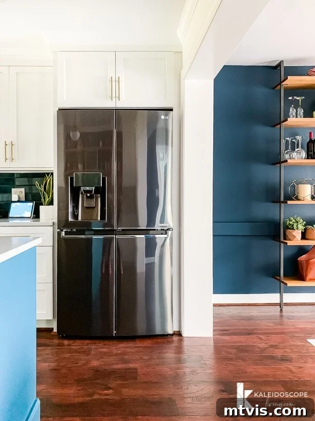white and teal kitchen open to navy blue dining room, illustrating the cohesive color palette