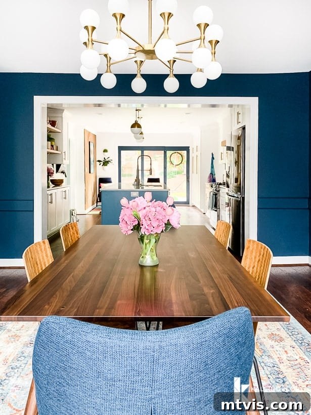 Navy blue eclectic dining room flowing into an open concept kitchen