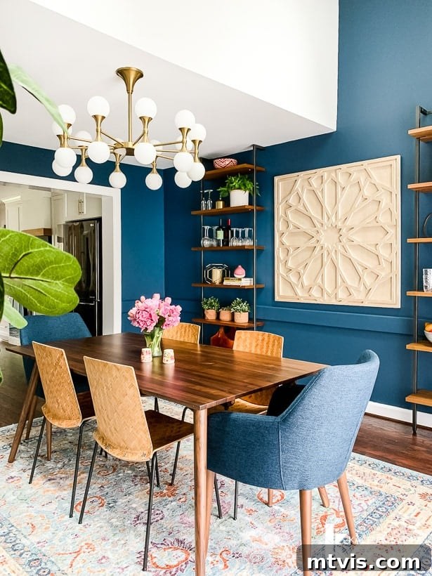 Navy blue dining room featuring Article dining table and chairs, showcasing an eclectic modern design