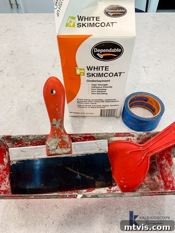 Wood and White Concrete: A DIY Range Hood Transformation 3 Collection of white skimcoat supplies including concrete mix, drywall knives, and adhesive