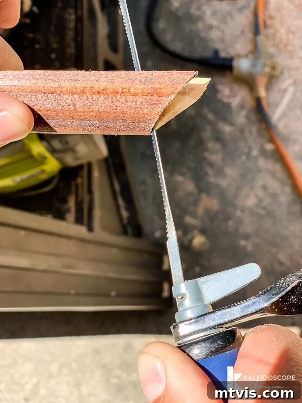 DIY Quarter Round Molding Installation 5 Hands use a small thin coping saw to cut the profile of the quarter round molding. The website KaleidoscopeLiving.com is in the right-hand bottom corner.