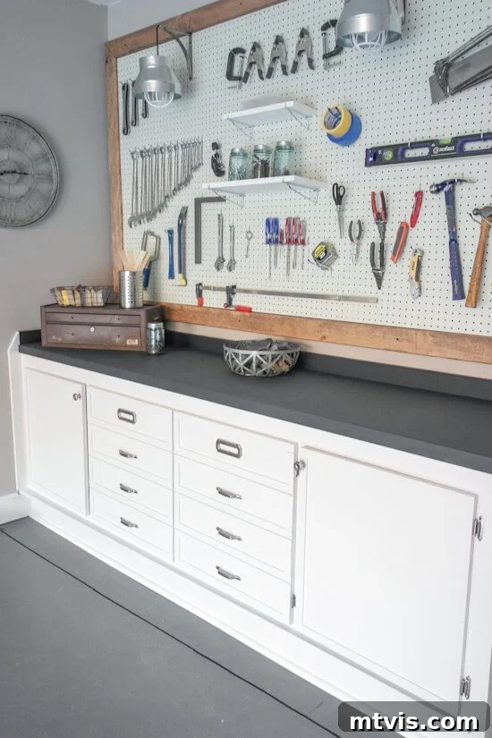 Organized workbench and framed pegboard in a garage, featuring a chalkboard paint countertop.