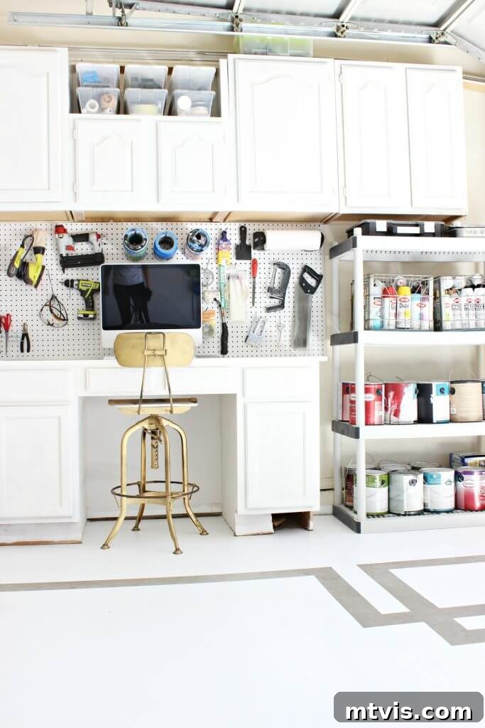 Organized garage with white cabinetry and a painted Greek key pattern on the floor, showcasing a stylish transformation.