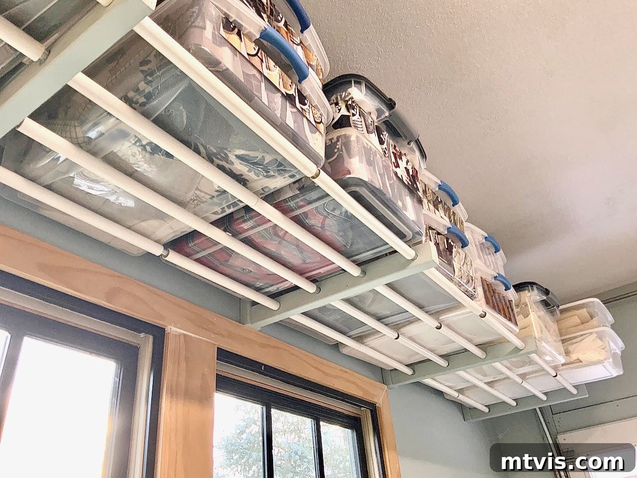 DIY overhead conveyor belt garage storage system, designed for easy sliding of heavy bins.
