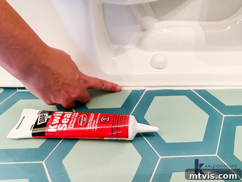 smoothing caulk bead at toilet base with finger