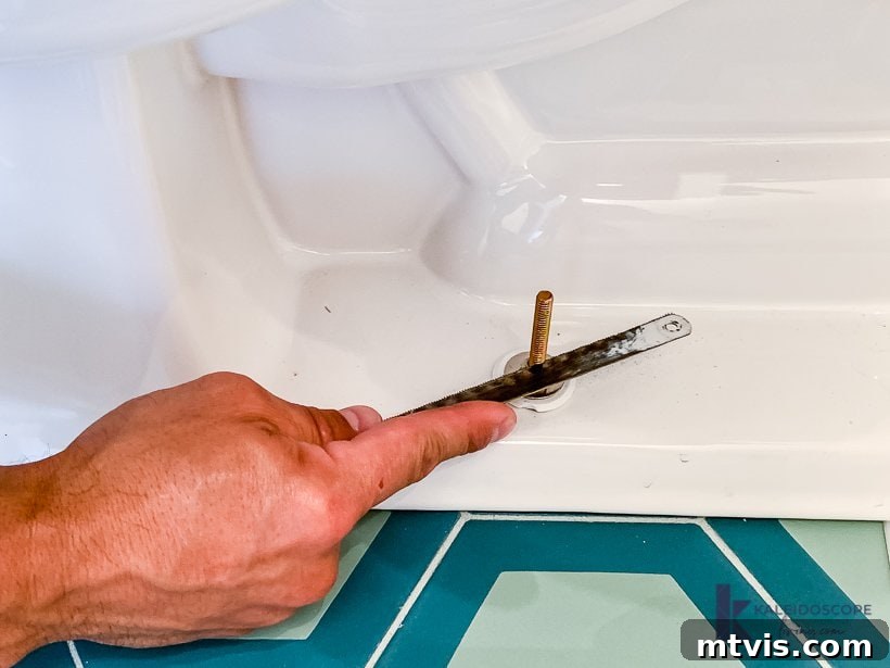 trimming excess toilet bolts with a hacksaw