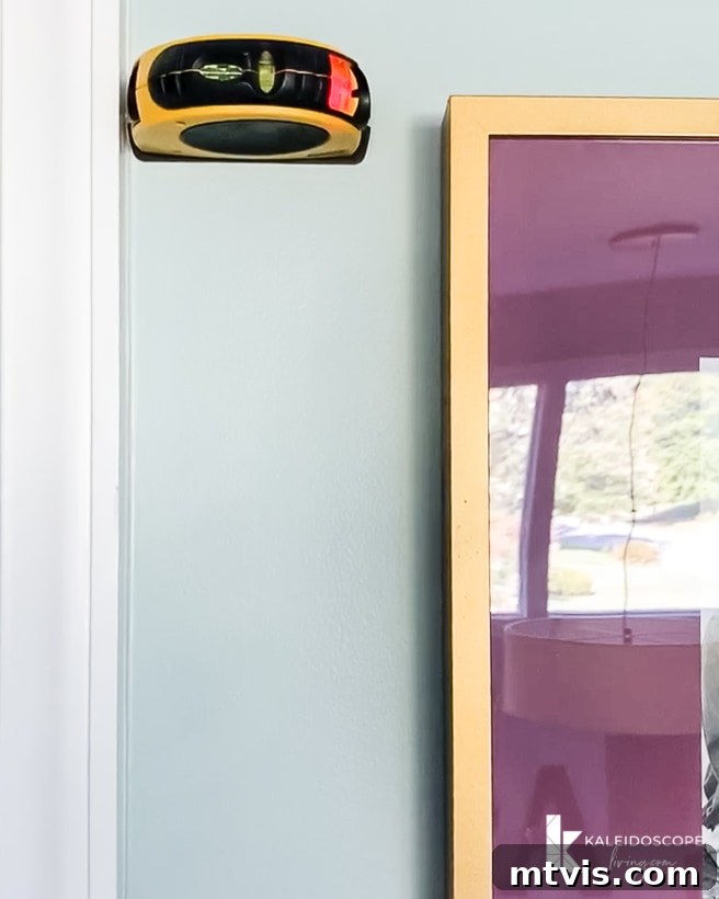 Bright DIY Memory Wall 10 Ensuring frames are perfectly level using a laser level during gallery wall installation
