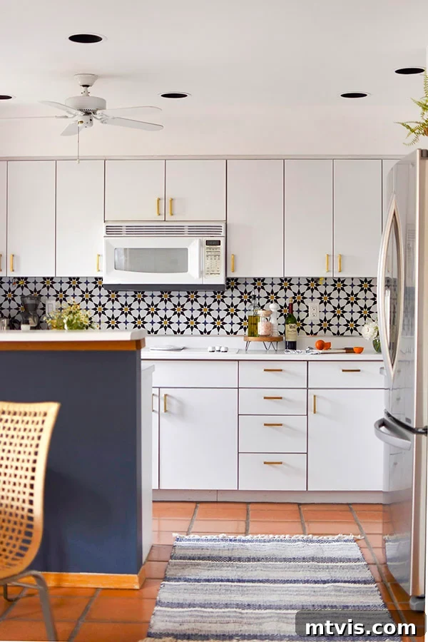 Budget DIY Kitchen Backsplash Makeovers 10 A dark blue and white kitchen features a striking geometric wallpaper backsplash, offering a modern aesthetic.