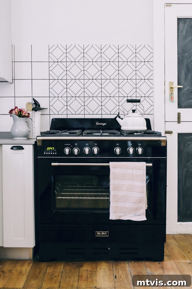 Budget DIY Kitchen Backsplash Makeovers 11 Cricut vinyl designs form a simple, renter-friendly backsplash, adding character to this black and white kitchen.