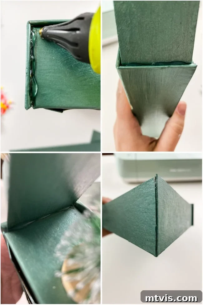 Personalized Advent Calendar Project with Cricut Explore Air 2 7 Hot glue gun being used to attach the painted chipboard rooftop to the paper mache Advent calendar, creating a house-like structure.