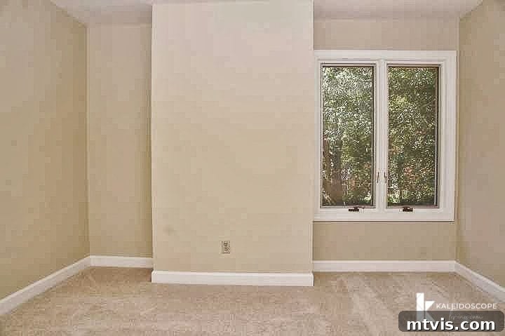 Another before image of Attley's empty and unremarkable bedroom, highlighting the drab walls and challenging layout, prior to the colorful girl's room makeover.